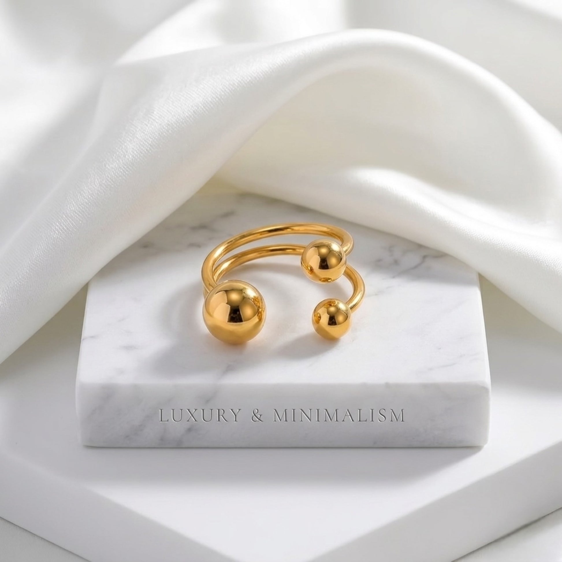 An angled perspective of the BEHI Mia Bta Ring resting on silk, showcasing its smooth and tarnish-resistant texture.