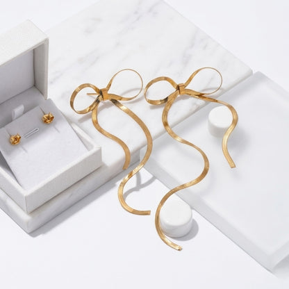 BEHI Lina Earrings displayed on luxury gift boxes, emphasizing their delicate ribbon-like silhouette.