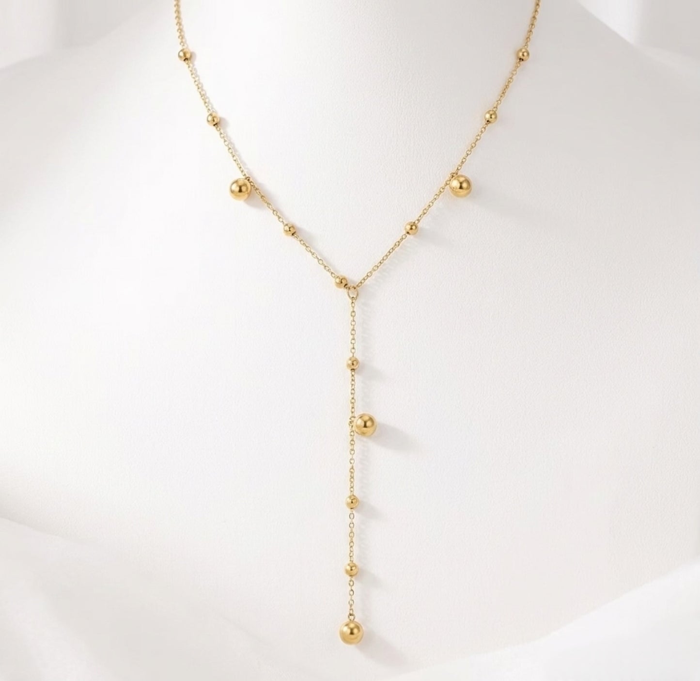 BEHI Rovena Necklace displayed on a white bust, emphasizing the graceful drape of the beaded lariat design.