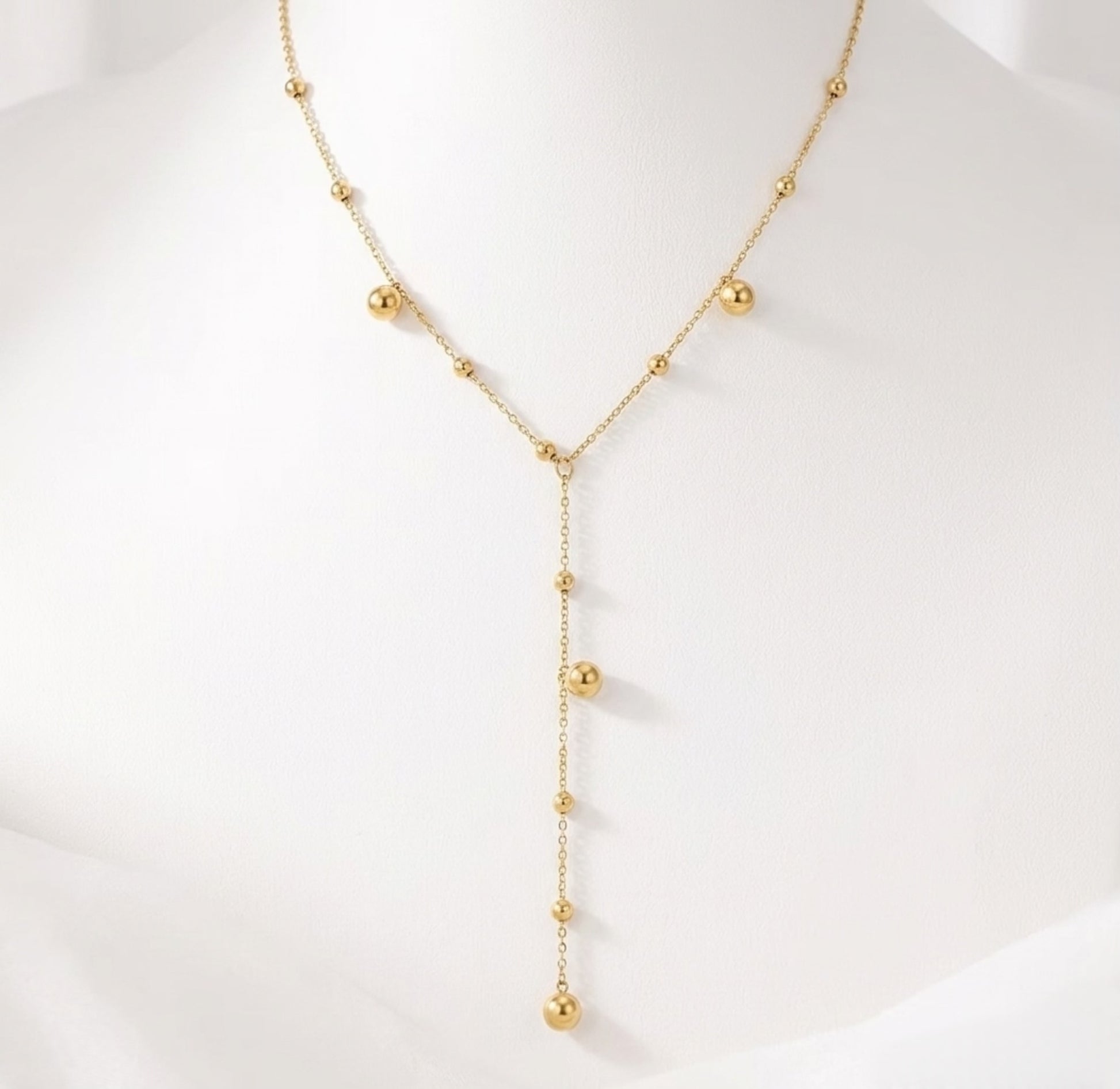 BEHI Rovena Necklace displayed on a white bust, emphasizing the graceful drape of the beaded lariat design.