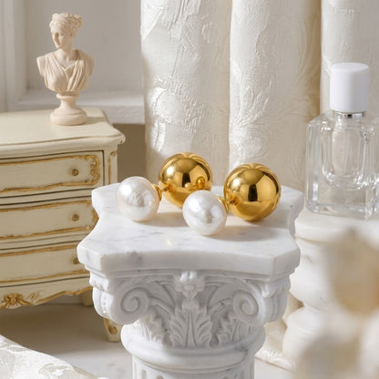 BEHI ROWA earrings featuring a 18k PVD gold plated small sphere with an imitation pearl piece close up