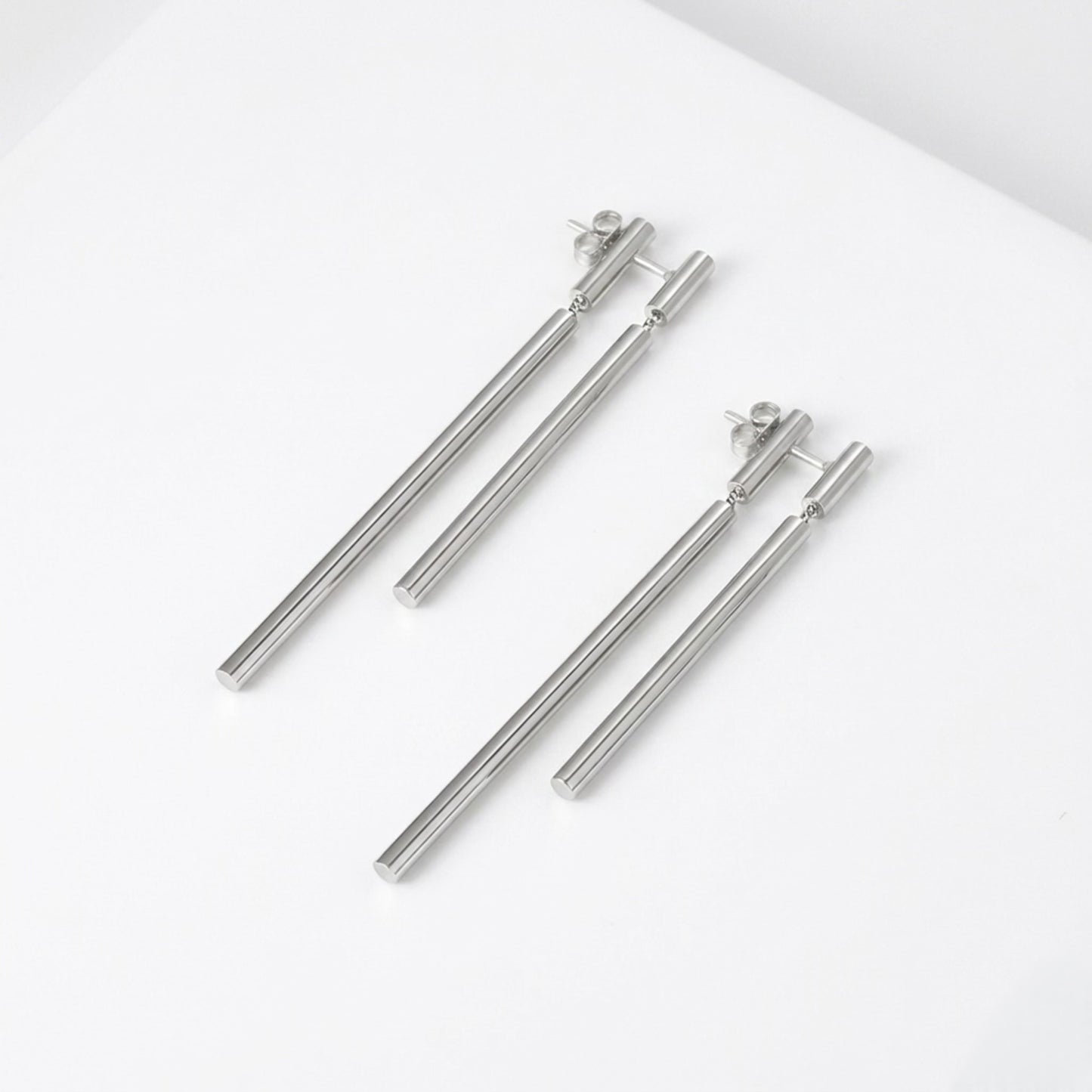 BEHI Deffi Earrings in silver finish, showcasing the sleek, waterproof, and hypoallergenic metallic triple-rod design.