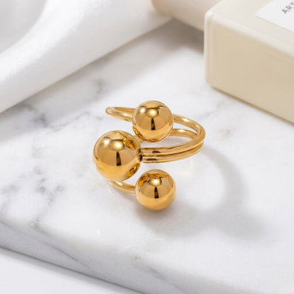 An angled perspective of the gold BEHI Mia Ring, emphasizing the smooth, high-polish texture of the triple-sphere band.