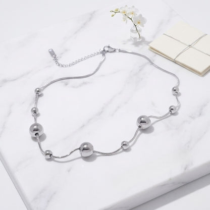 An angled perspective of the silver BEHI Kassia Necklace, showcasing the smooth, tarnish-free texture and modern geometric flow.