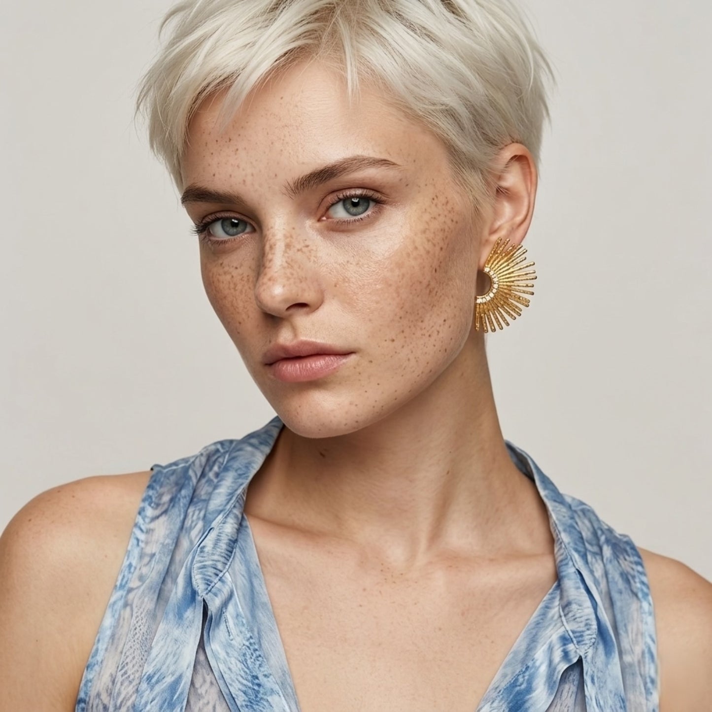 A front view of the waterproof BEHI Indigamond Earrings on a model, highlighting their radiant, sunburst design.