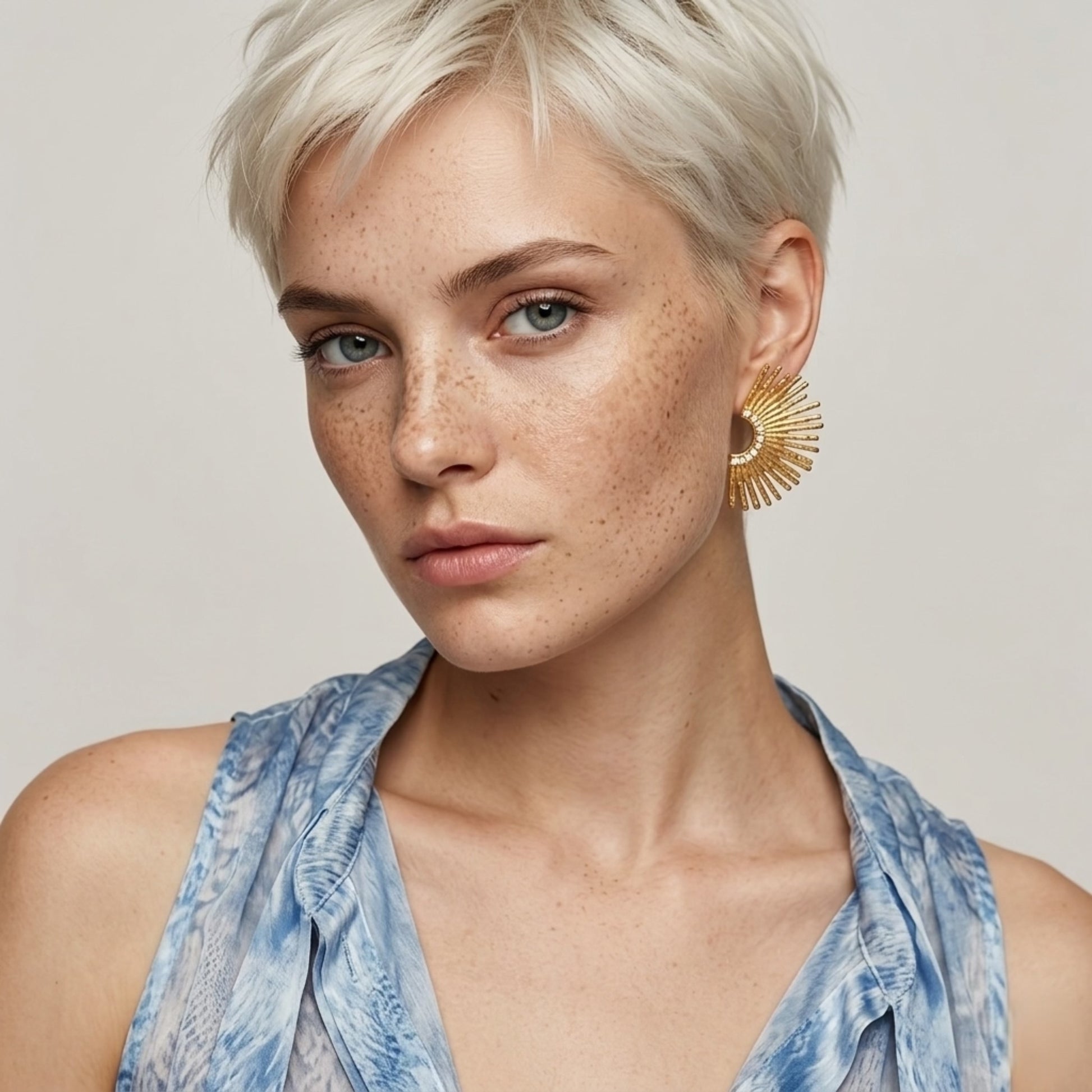 A front view of the waterproof BEHI Indigamond Earrings on a model, highlighting their radiant, sunburst design.