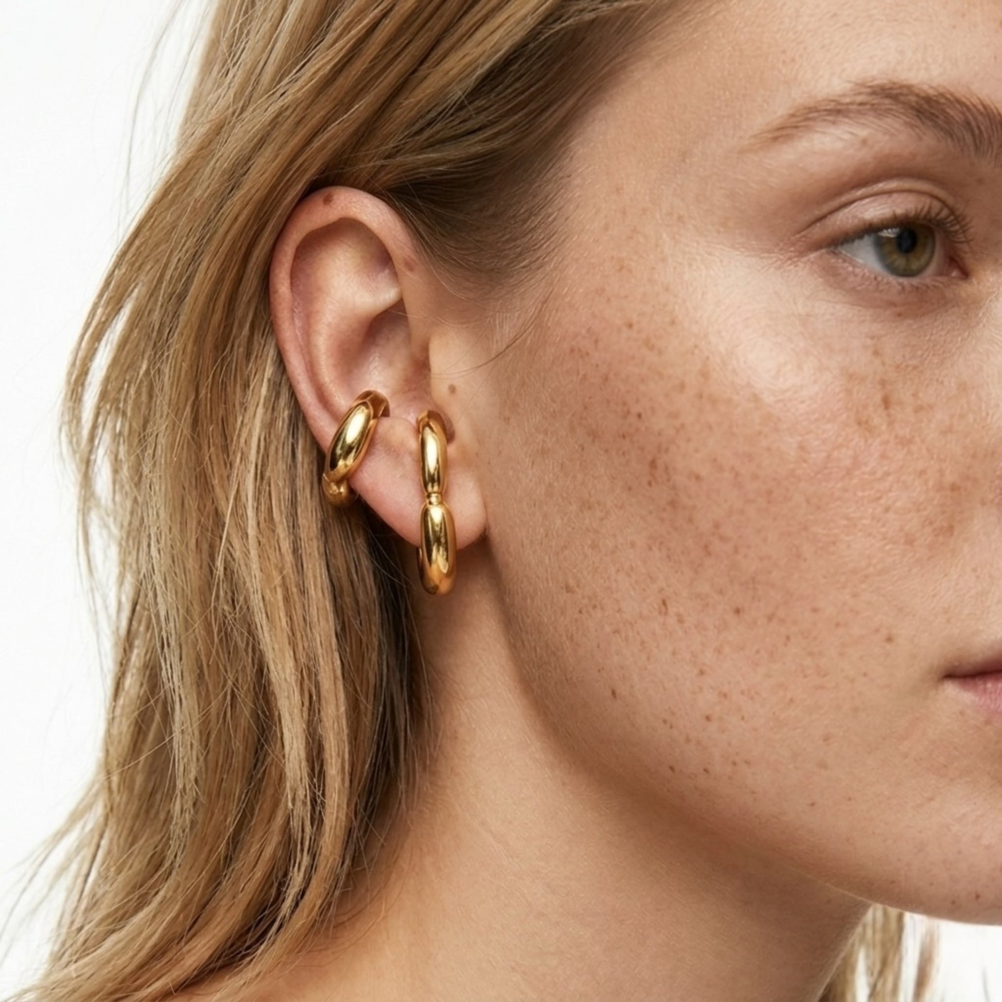 BEHI Petra Earrings worn on the ear to show the hypoallergenic fit and radiant gold finish.