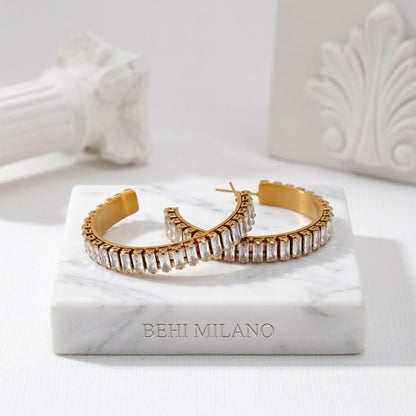 BEHI RIENA 18k PVD gold-plated hypoallergenic stainless steel hoop earrings with multiple rows of Zircon gemstones set in a solid pattern, designed to be worn on the earlobes.