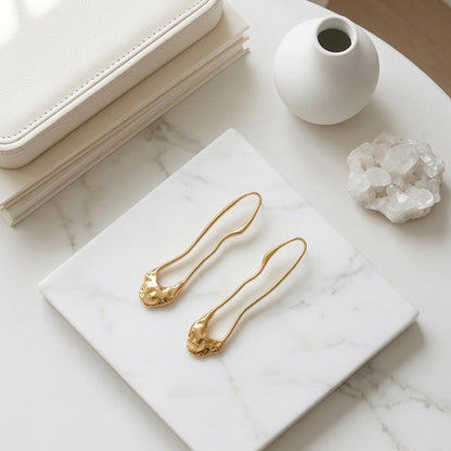 BEHI TRINI 18k PVD gold-plated waterproof stainless steel earrings with an elongated organic shape in shiny gold finish.