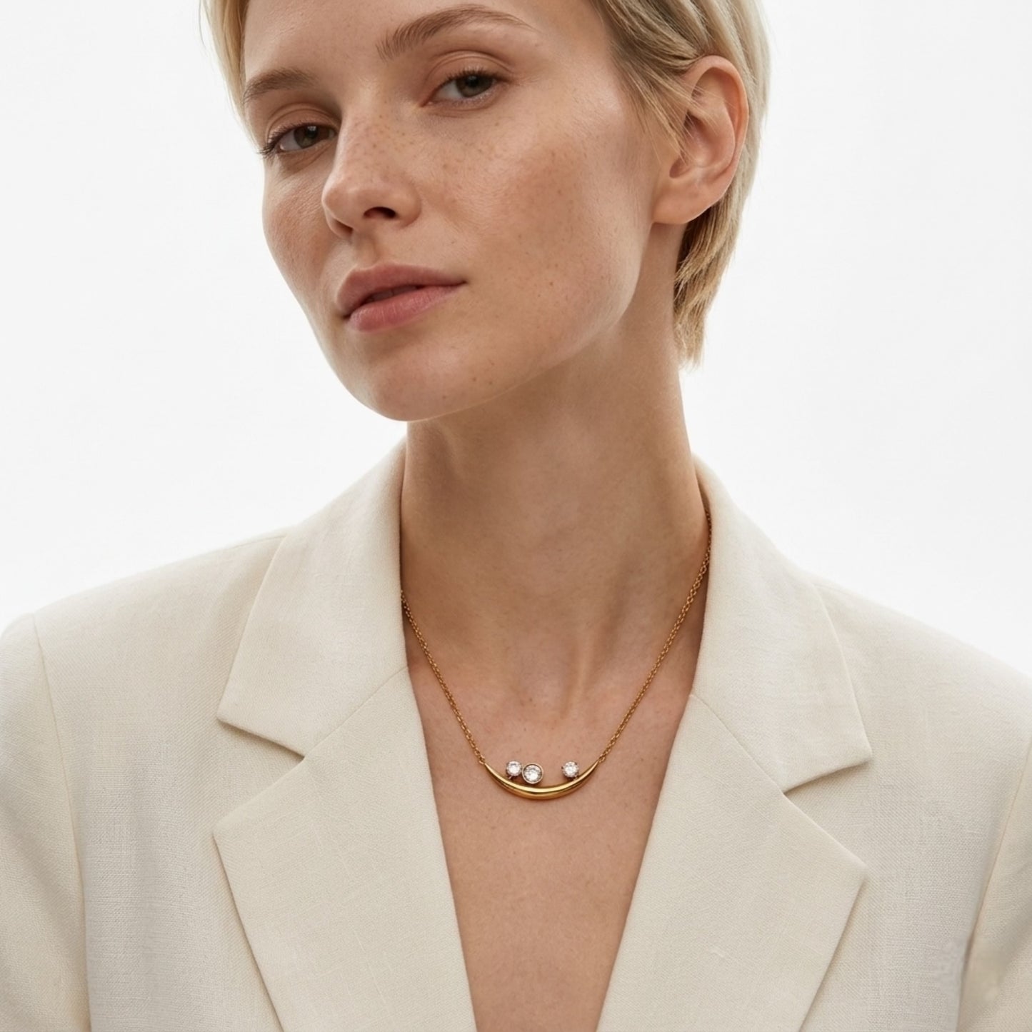 BEHI Rabiya Necklace | 18k PVD gold-plated stainless steel necklace with a crescent-shaped pendant featuring three clear zircon stones set within the curve, attached to a gold chain | Waterproof, Hypoallergenic and tarnish-free