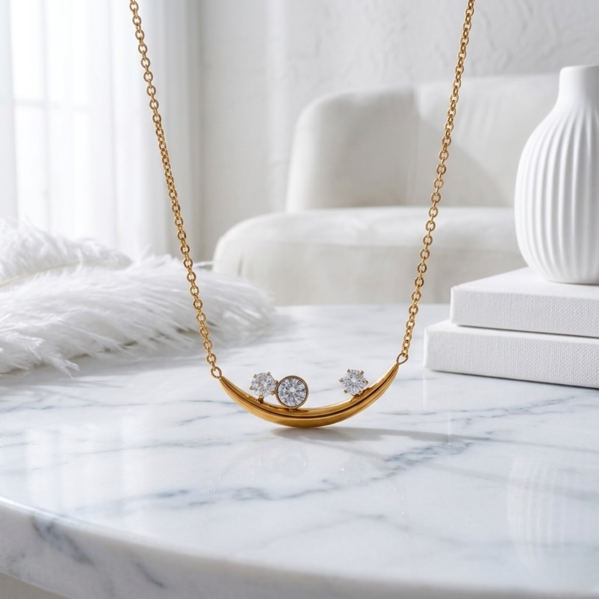 BEHI Rabiya Necklace | 18k PVD gold plated stainless steel necklace with a crescent-shaped pendant featuring three clear zircon stones set within the curve, attached to a gold chain | Waterproof, Hypoallergenic and tarnish-free