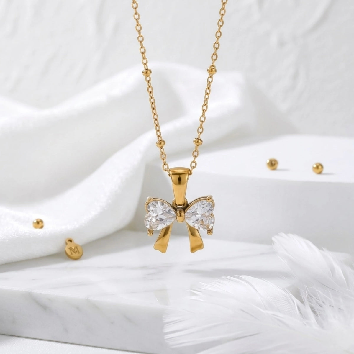 BEHI MILANO Dalia Necklace — gold zircon butterfly pendant on white silk fabric with feather accent