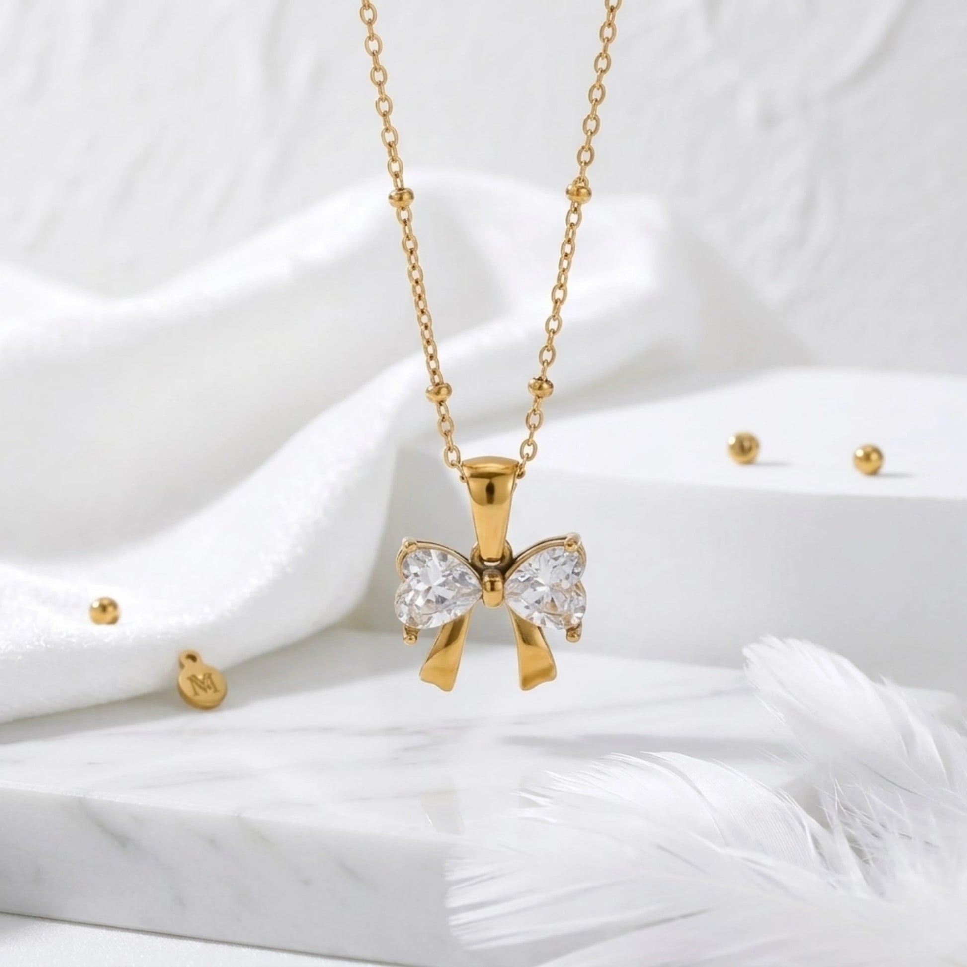 BEHI MILANO Dalia Necklace — gold zircon butterfly pendant on white silk fabric with feather accent