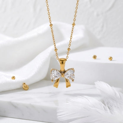BEHI MILANO Dalia Necklace — gold zircon butterfly pendant on white silk fabric with feather accent
