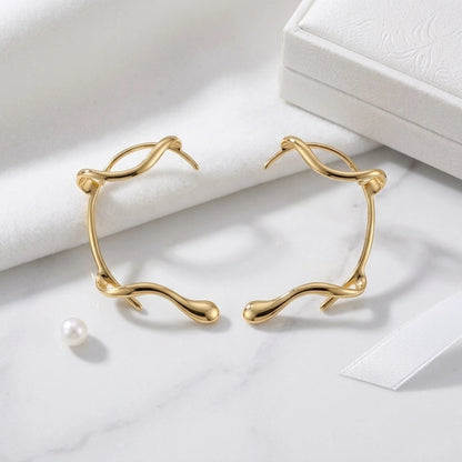 Close-up detail BEHI MILANO Afrodite Ear Cuffs — sculptural gold wrap shape, PVD-coated brass, hypoallergenic tarnish-free earring