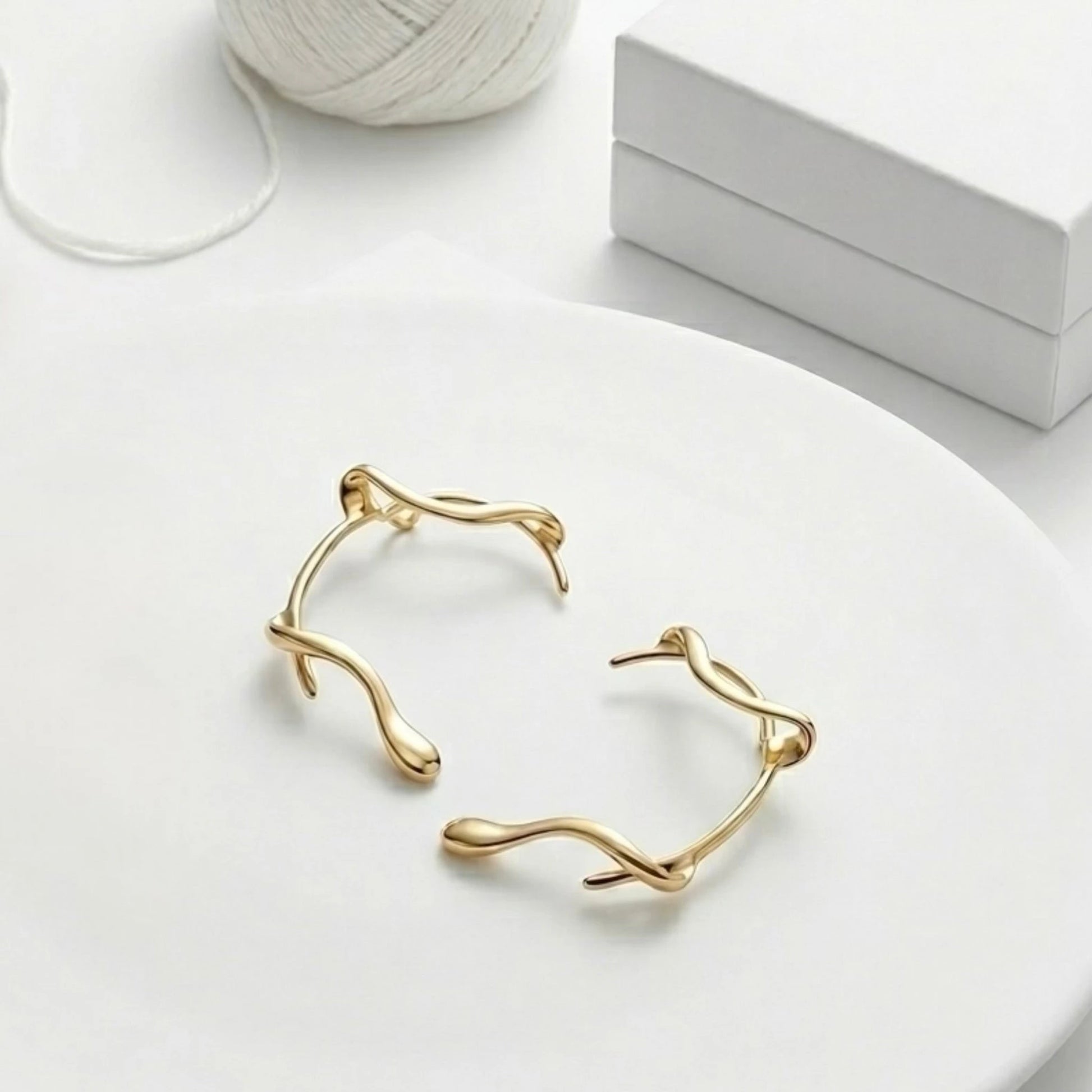 BEHI MILANO Afrodite Ear Cuffs flat lay — pair of gold wrap-around ear cuffs, 18k gold-plated brass, no-piercing statement earrings
