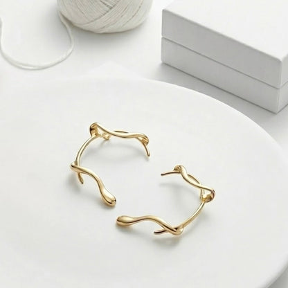 BEHI MILANO Afrodite Ear Cuffs flat lay — pair of gold wrap-around ear cuffs, 18k gold-plated brass, no-piercing statement earrings