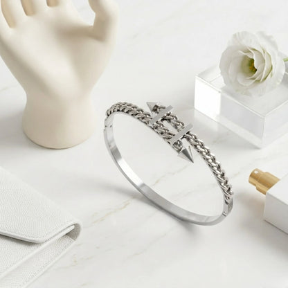 BEHI MILANO Alane Bracelet silver flat lay on marble — curb chain spike bangle with hand display prop and white flower, silver-plated stainless steel