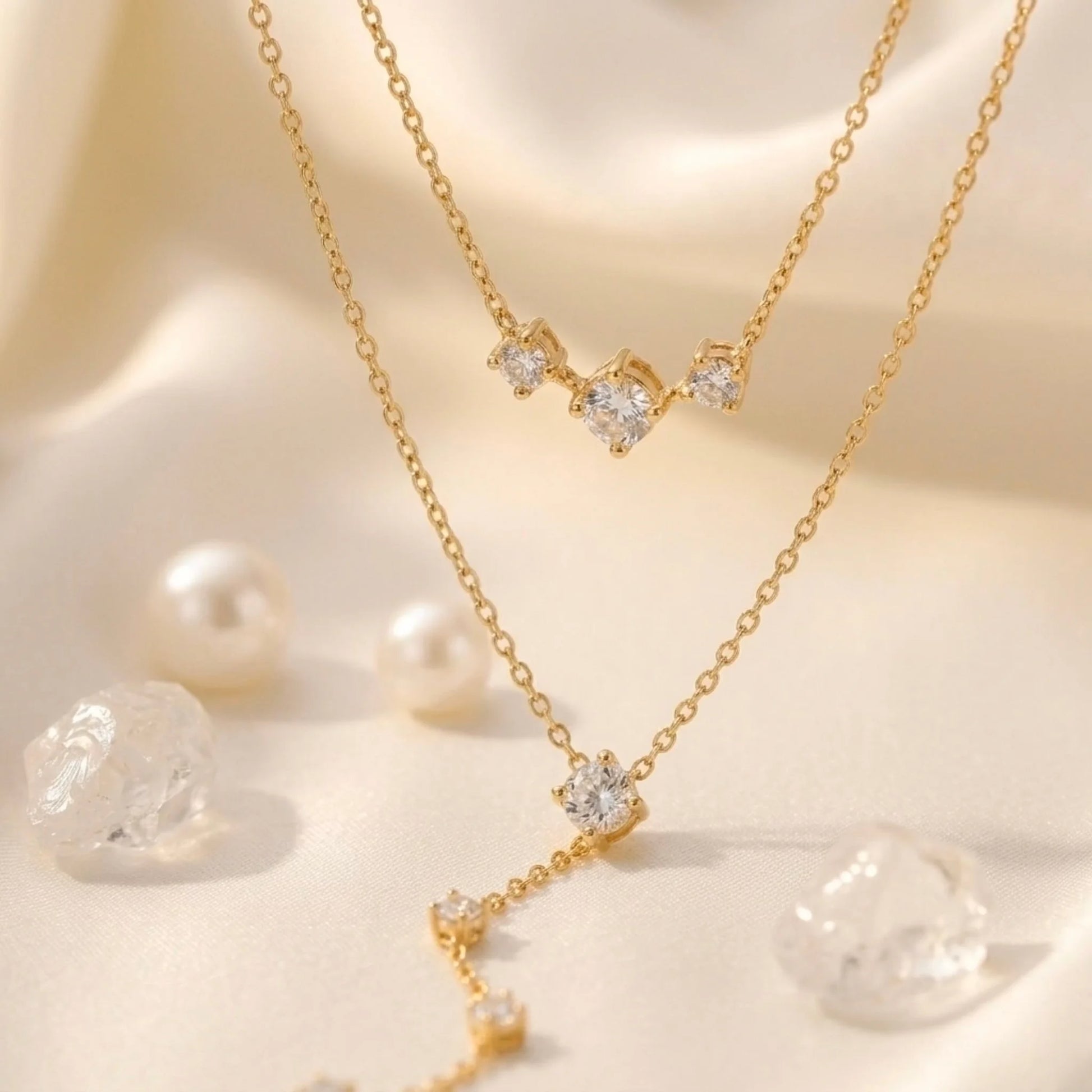 BEHI MILANO Alda Necklace close-up — brilliant-cut zircon stones on 18k gold-plated chain, three-stone bar and Y-drop pendant detail