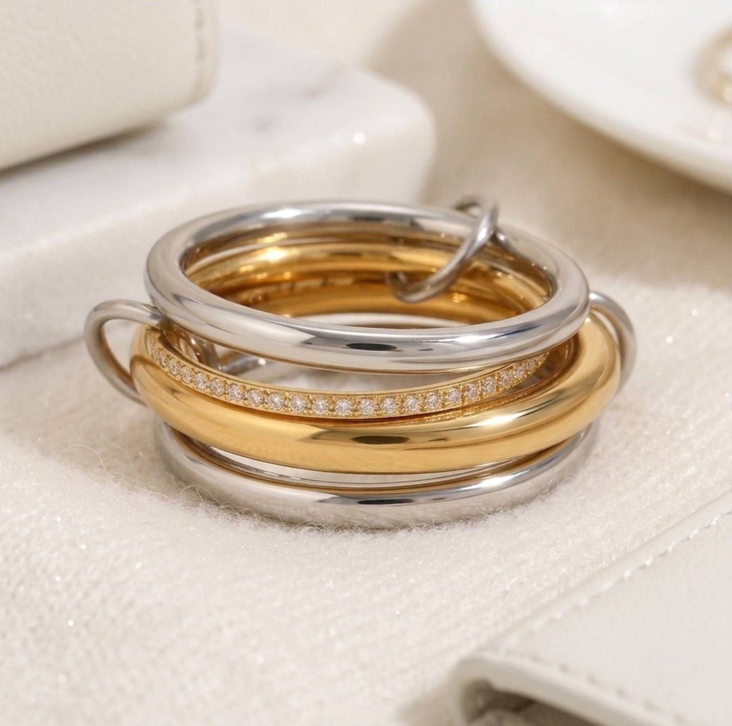 BEHI MILANO Alina Ring close-up — zircon pavé centre band between polished gold and silver linked bands, hypoallergenic stainless steel