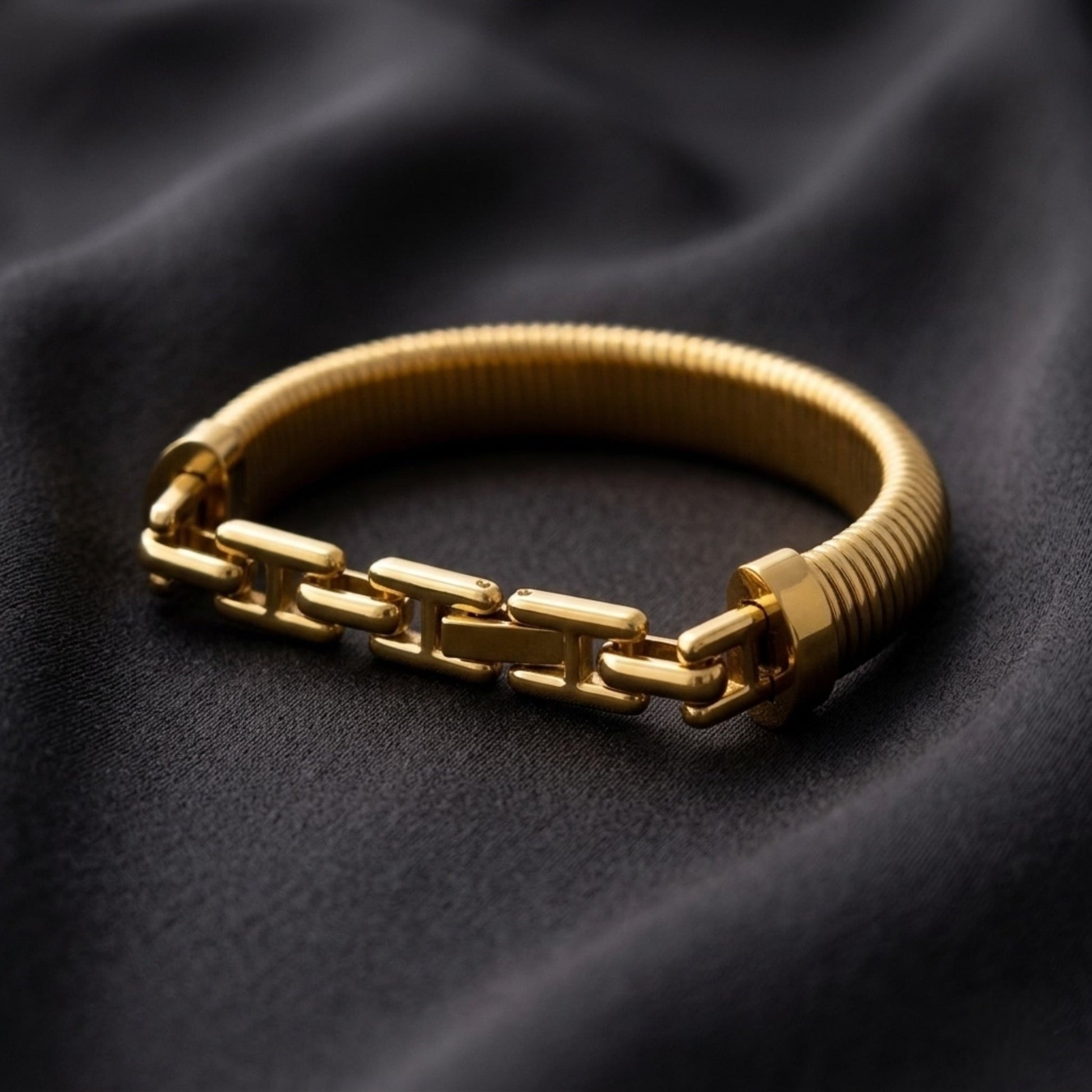 BEHI MILANO Almond Bracelet gold dark background — wide ribbed 18k gold-plated bangle, statement stainless steel jewelry designed in Milan