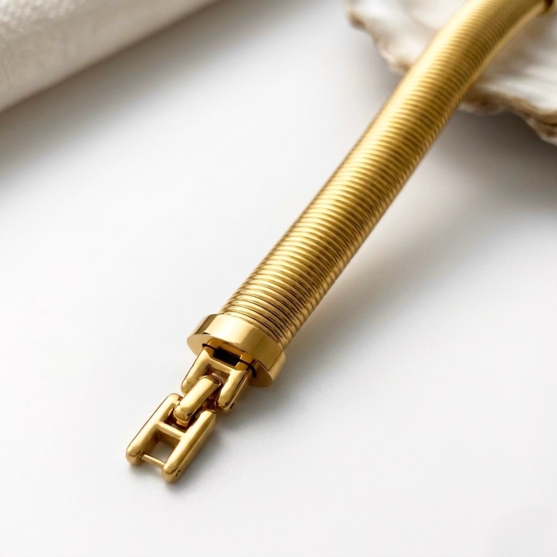 BEHI MILANO Almond Bracelet gold detail — wide ribbed bangle texture close-up, 18k PVD-coated stainless steel, polished gold finish
