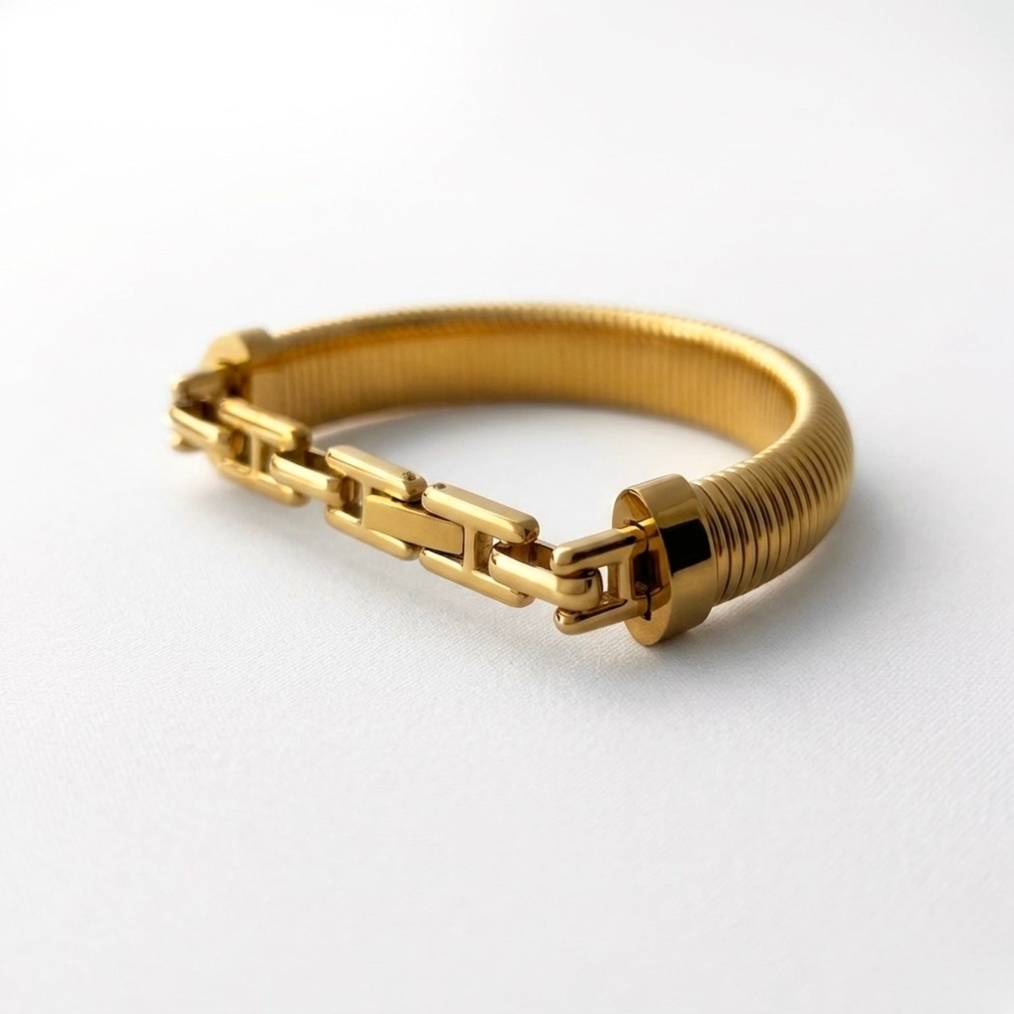 BEHI MILANO Almond Bracelet gold styled flat lay — wide ribbed gold bangle, 18k gold-plated stainless steel, waterproof fine jewelry