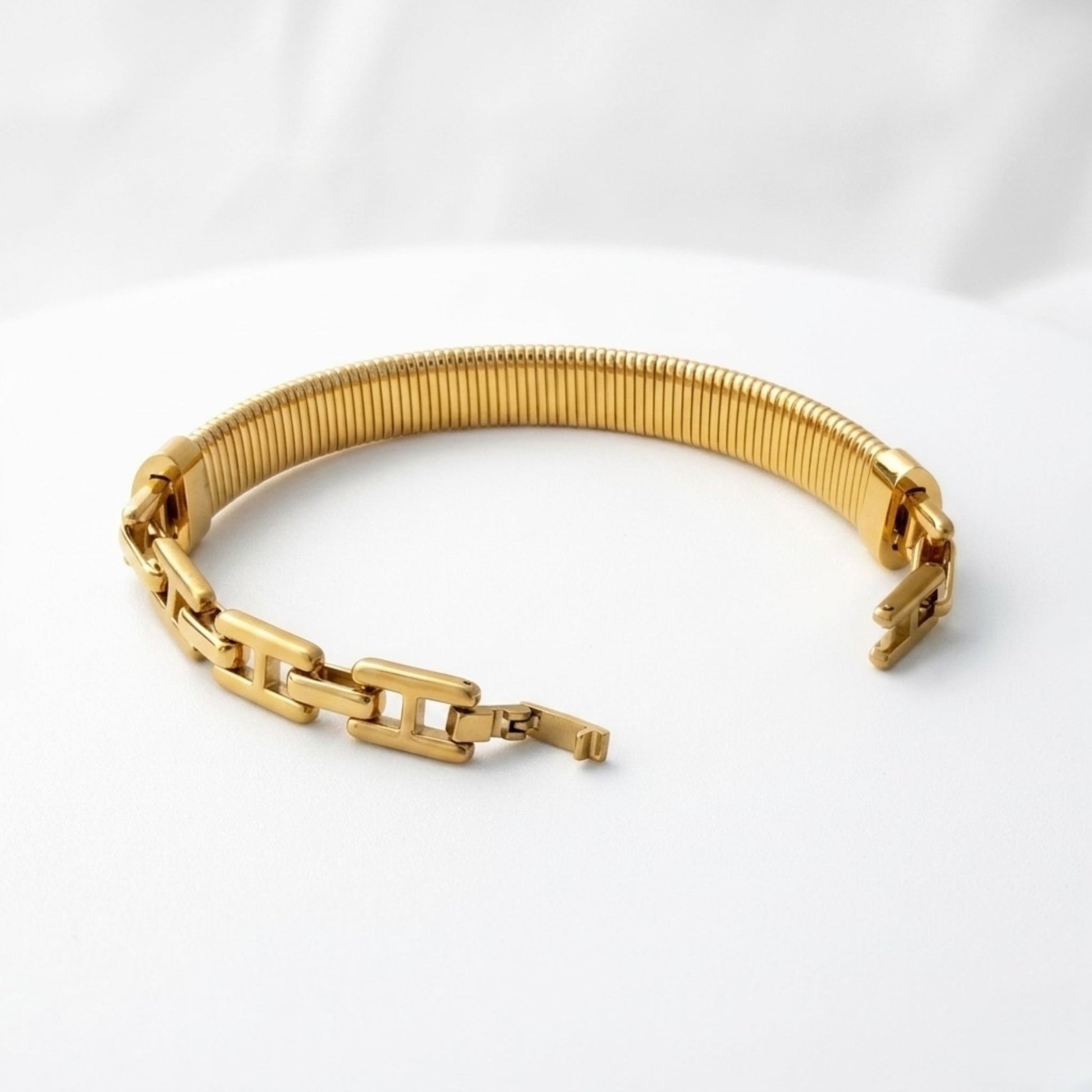 BEHI MILANO Almond Bracelet gold styled flat lay — wide ribbed gold bangle, 18k gold-plated stainless steel, waterproof fine jewelry