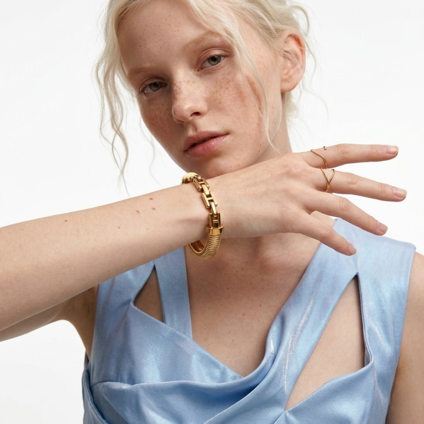 BEHI MILANO Almond Bracelet worn on model — wide gold ribbed bangle on wrist, 18k gold-plated stainless steel statement bracelet