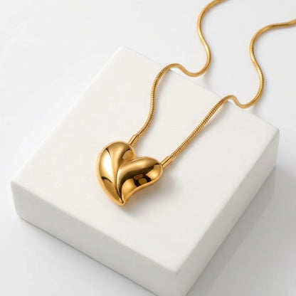 BEHI MILANO Amorino Necklace — 18k gold heart pendant on snake chain displayed on white stand