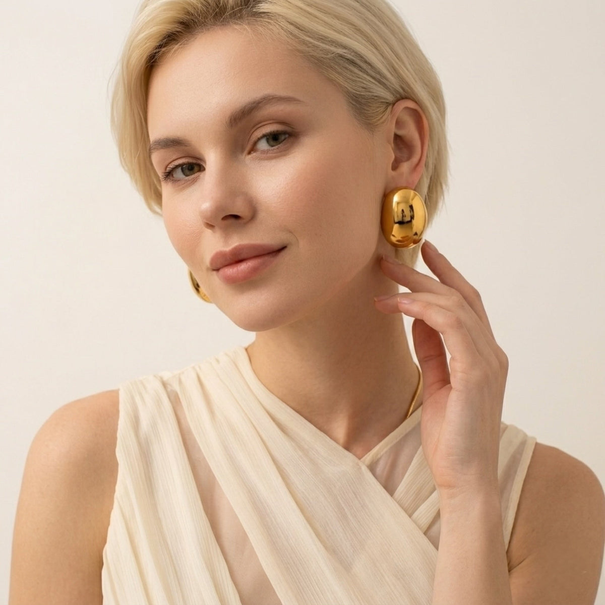 BEHI MILANO Annarita Earrings — close-up portrait of model wearing 18k gold oval stud earrings