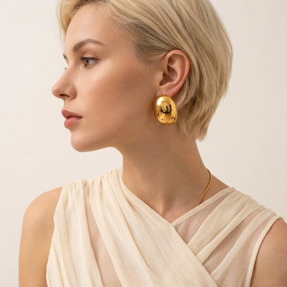 BEHI MILANO Annarita Earrings — model side profile wearing gold chunky oval dome studs