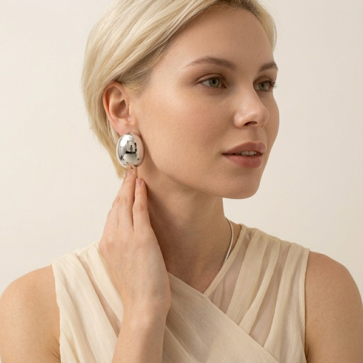 BEHI MILANO Annarita Earrings — model wearing silver stainless steel oval dome statement studs