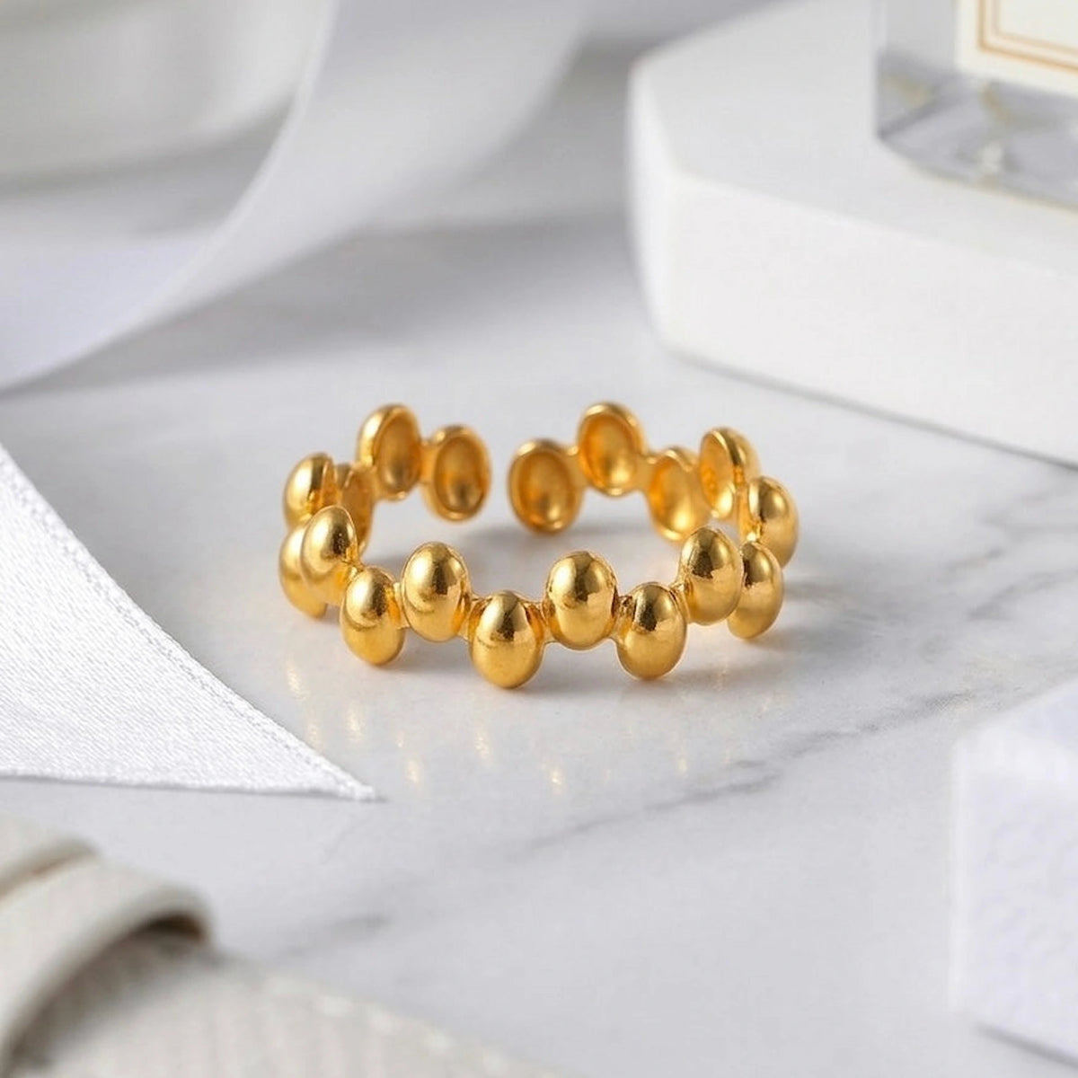 BEHI MILANO Anya Ring — detailed view of gold beaded texture on marble surface