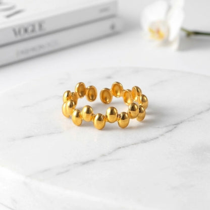BEHI MILANO Anya Ring — 18k gold beaded ring styled on white marble with magazine backdrop
