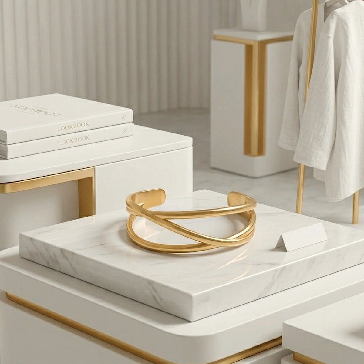 BEHI MILANO Ariella Bracelet — 18k gold intertwined cuff styled on white marble display pedestal