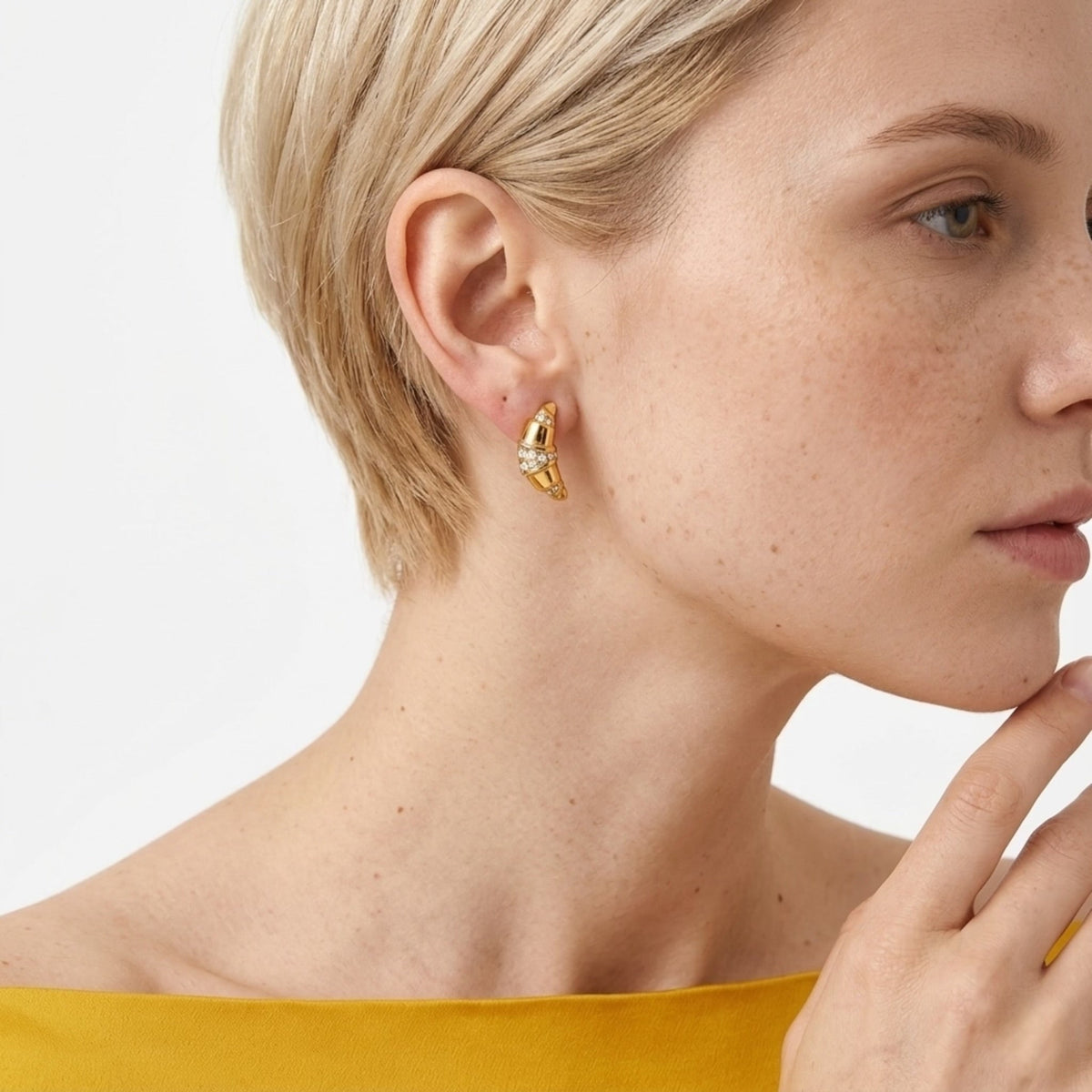 BEHI MILANO Aris Earrings — side profile of blonde model in yellow top wearing gold croissant earrings