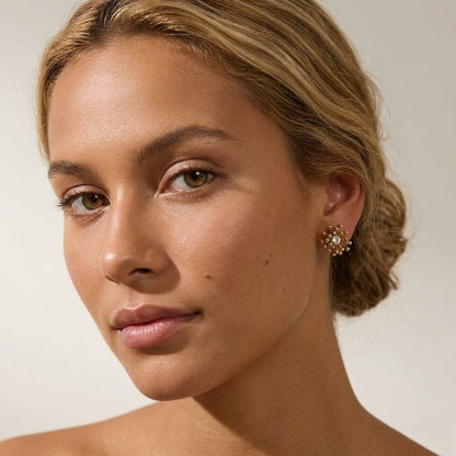 BEHI MILANO Artymanos Earrings — frontal portrait of model wearing textured gold crystal earrings