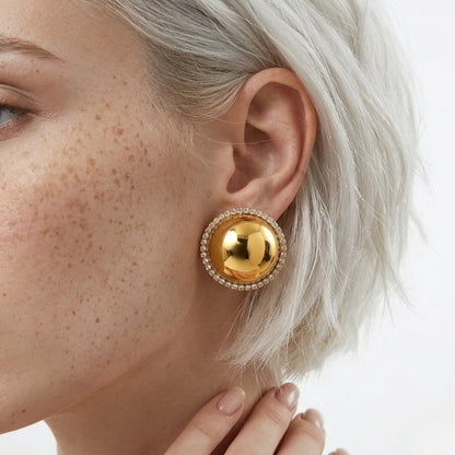 BEHI MILANO Audrey Earrings — detailed close-up of gold dome crystal stud earring on model's ear