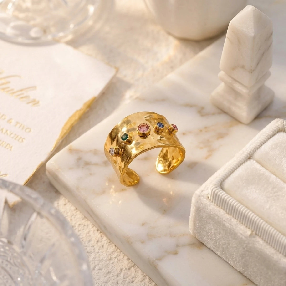 BEHI MILANO Azzu Ring — 18k gold multi-gemstone ring on velvet tray with luxury stationery card