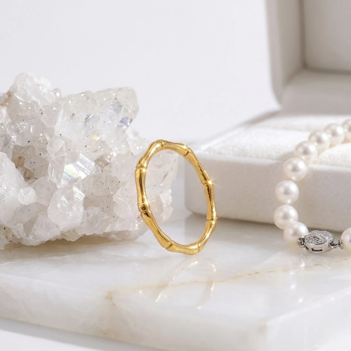 BEHI MILANO Bamboo Ring — gold band ring displayed with crystal quartz cluster and pearl strand