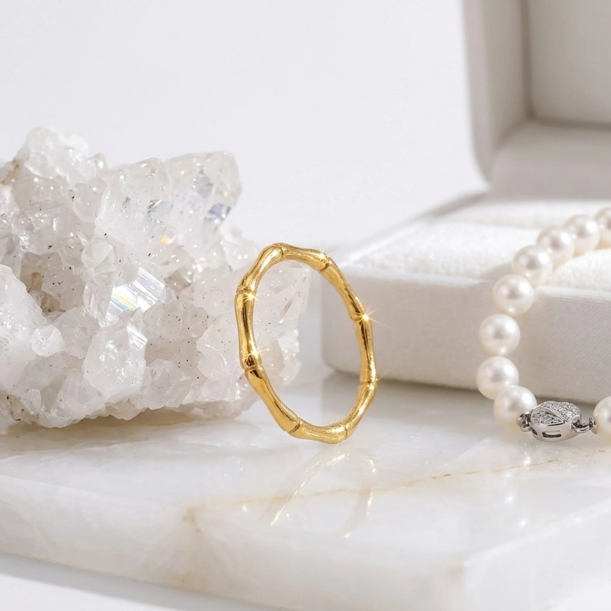 BEHI MILANO Bamboo Ring — gold band ring displayed with crystal quartz cluster and pearl strand