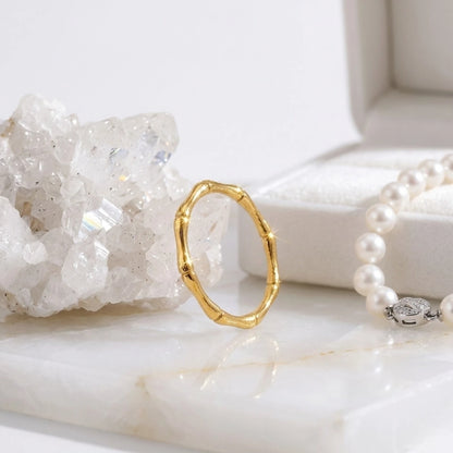 BEHI MILANO Bamboo Ring — gold band ring displayed with crystal quartz cluster and pearl strand
