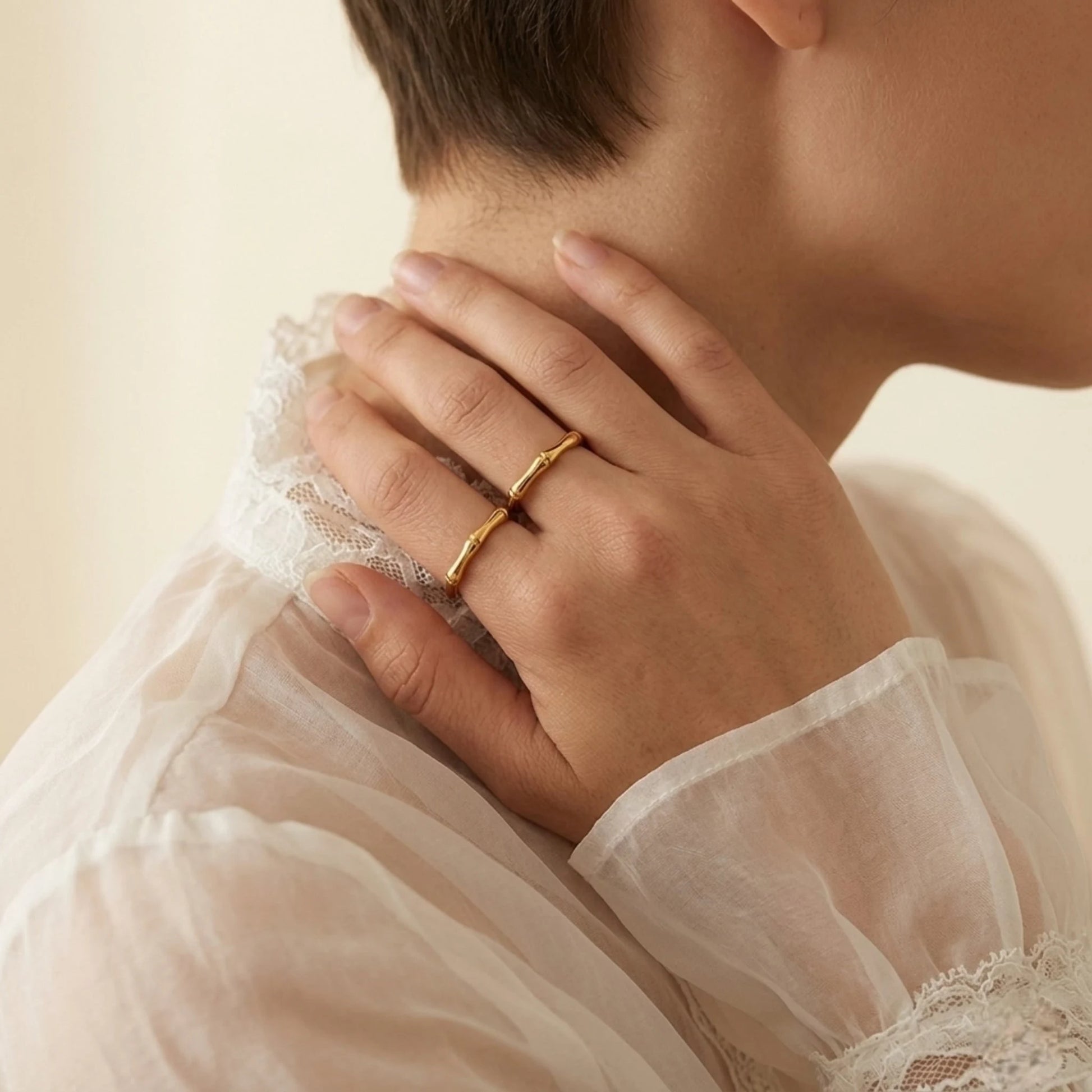 BEHI MILANO Bamboo Ring — model wearing thin gold bamboo ring on finger with white lace