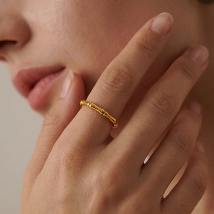 BEHI MILANO Bamboo Ring — close-up of model holding hand near neck wearing delicate gold ring