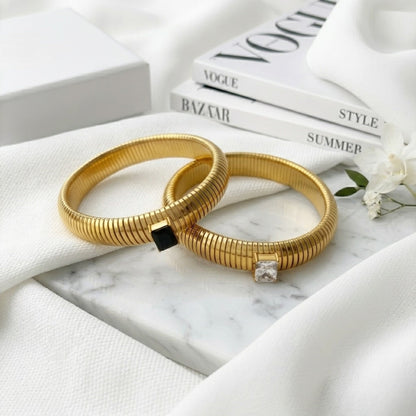 BEHI MILANO Beatriz Bracelets — black and white solitaire stone gold stretch cuffs displayed together on marble