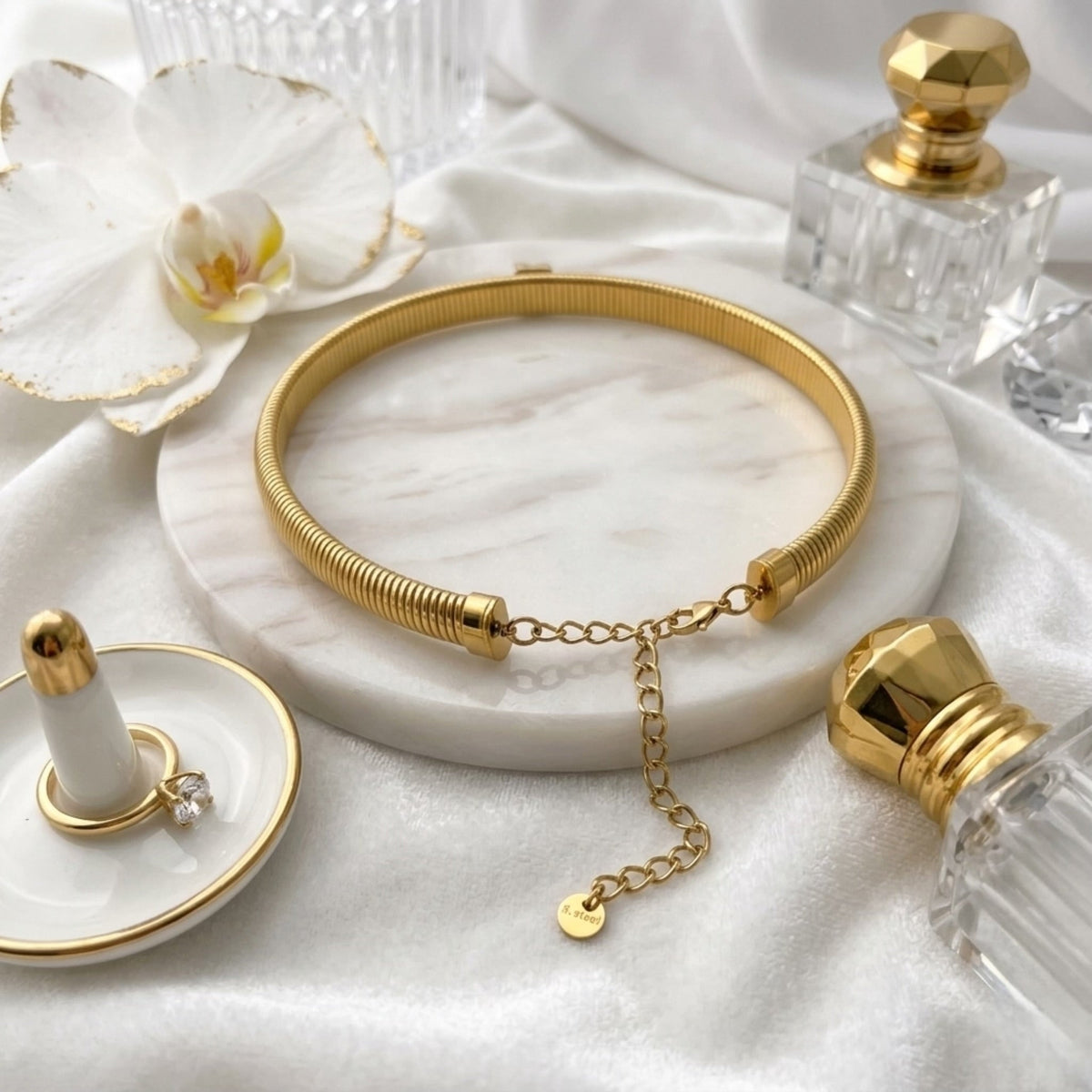 BEHI MILANO Beatriz Choker — gold ribbed choker necklace styled on tray with luxury perfume bottles