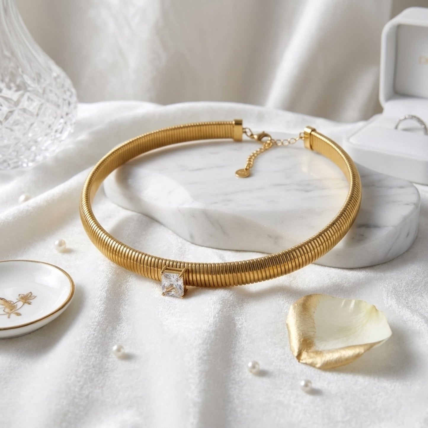 BEHI MILANO Beatriz Choker — gold cubic zirconia choker laying on white silk background