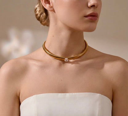 BEHI MILANO Beatriz Choker — model wearing gold solitaire gem choker with white strapless gown
