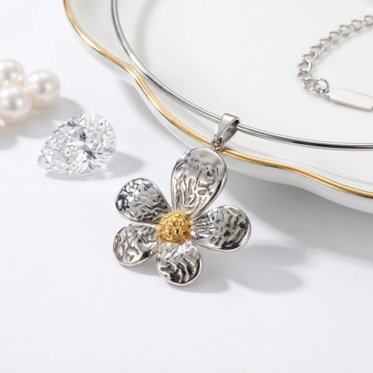BEHI MILANO Bloom Choker — silver neck wire and two-tone hammered flower pendant on white marble